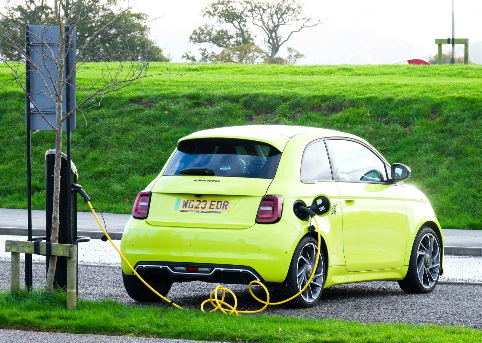 electric mini green car is at power pole