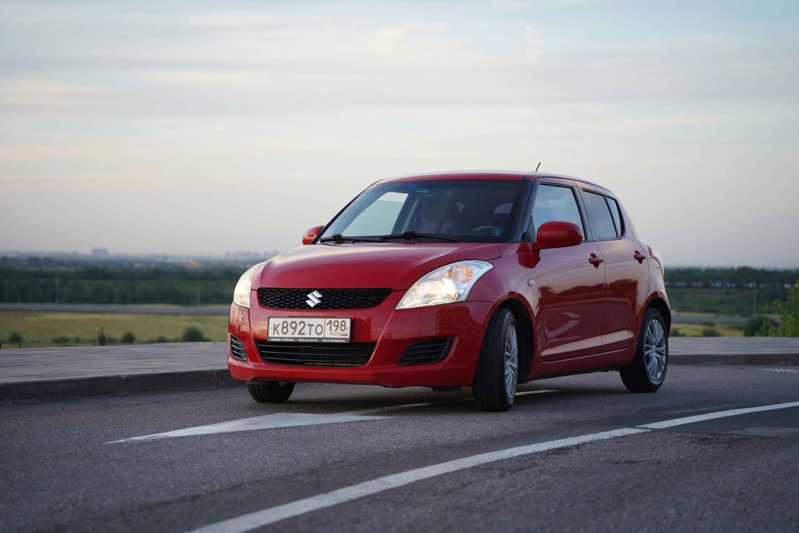 red suzuki alto car on road